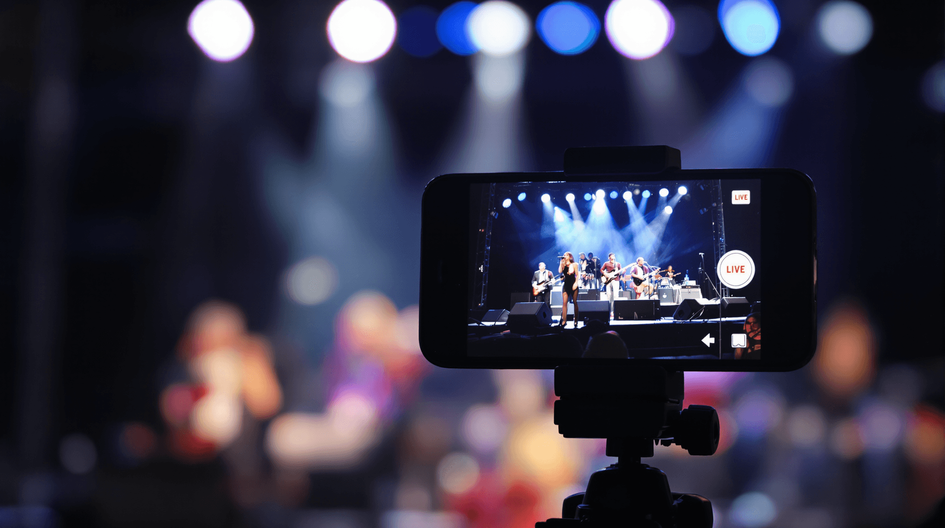 Smartphone on a tripod recording a musical concert for real-time video streaming.