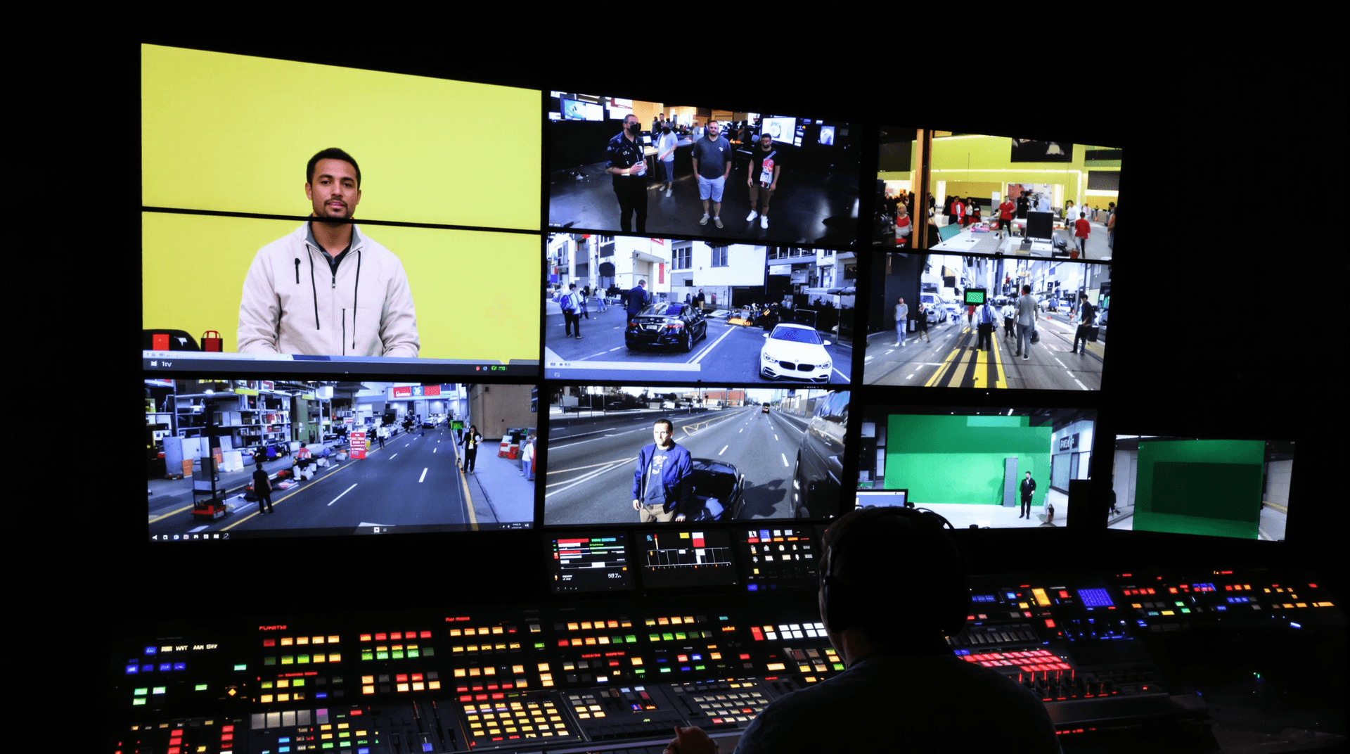 Operator managing video streams on multiple monitors in a video streaming studio.